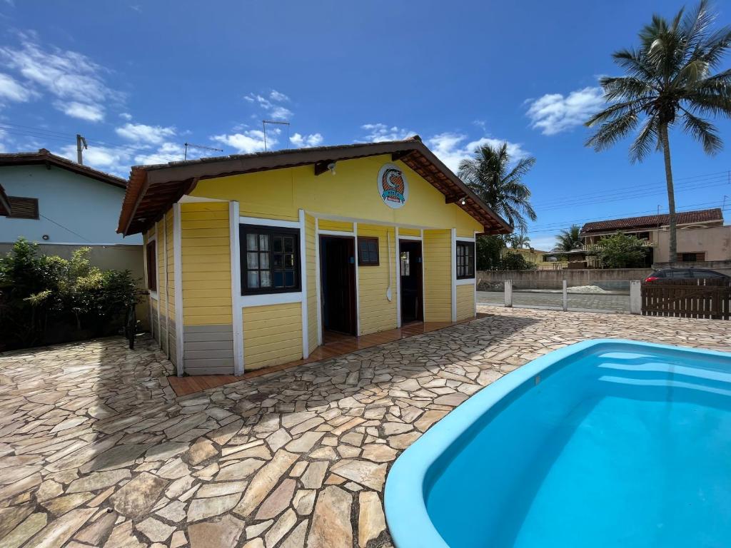 a rental house with a swimming pool in front of it at Chalé Master Caraguatatuba cond Alto Padrão Massaguaçu in Caraguatatuba