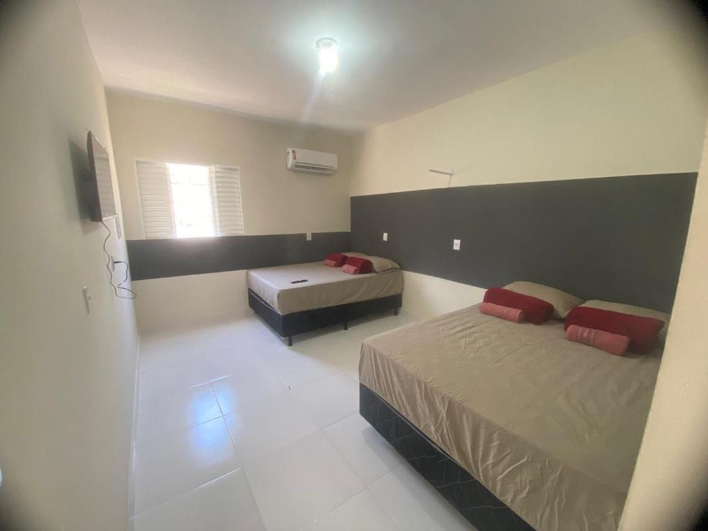 a bedroom with two beds and a window at Residencial pimenta - aluguel temporada - apto mobiliado in Cuiabá