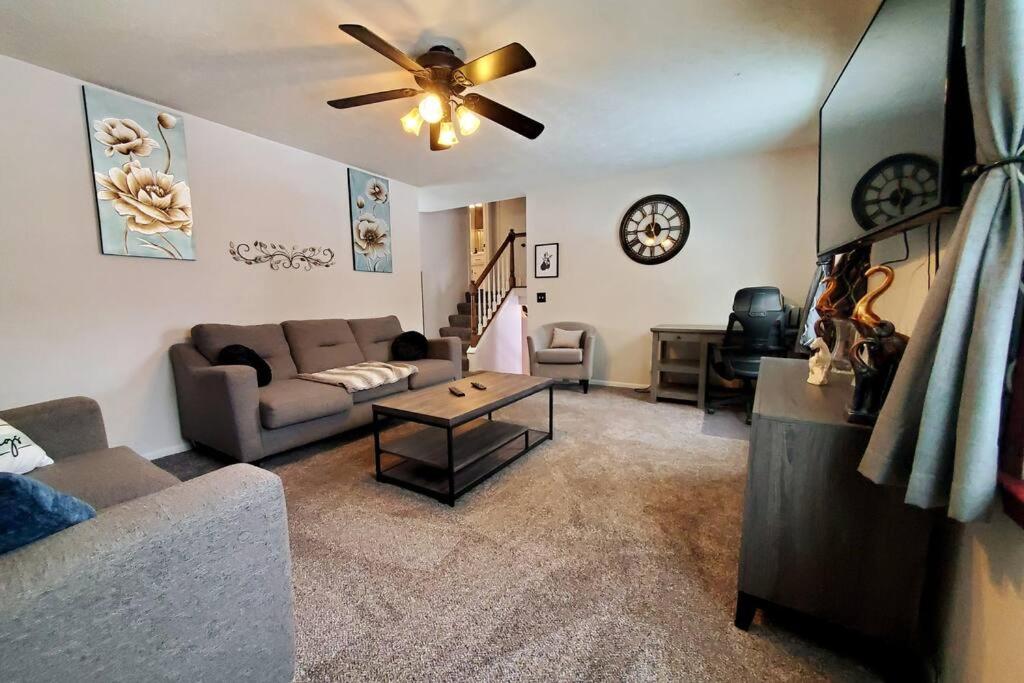 a living room with a couch and a ceiling fan at Maple. Pleasant 4 bedroom house with pool in Omaha