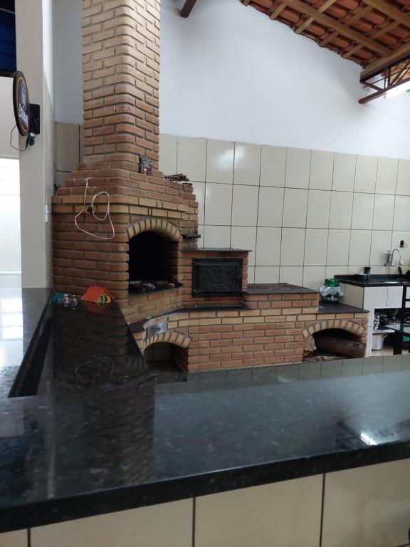 eine Küche mit einem Backsteinofen in einem Zimmer in der Unterkunft Chácara Goufran in Caçapava