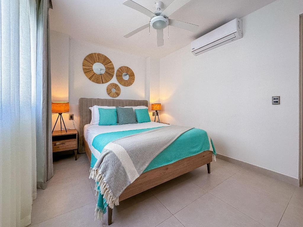 1 dormitorio con 1 cama y ventilador de techo en Apto de 2 hab y 2 bañ swim up a pasos de la playa en Punta Cana