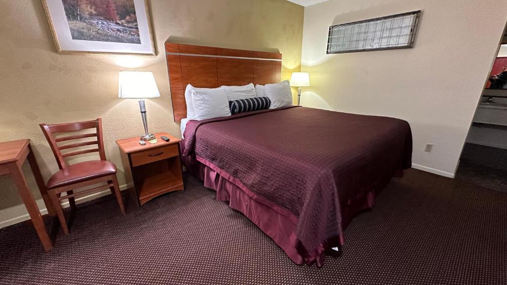 una camera d'albergo con letto e sedia di Economy Inn a Garnett