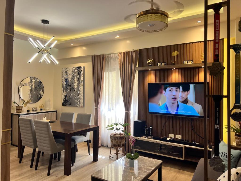 a living room with a dining table and a tv at Penthouse Condo Unit near Airport NAIA in Manila