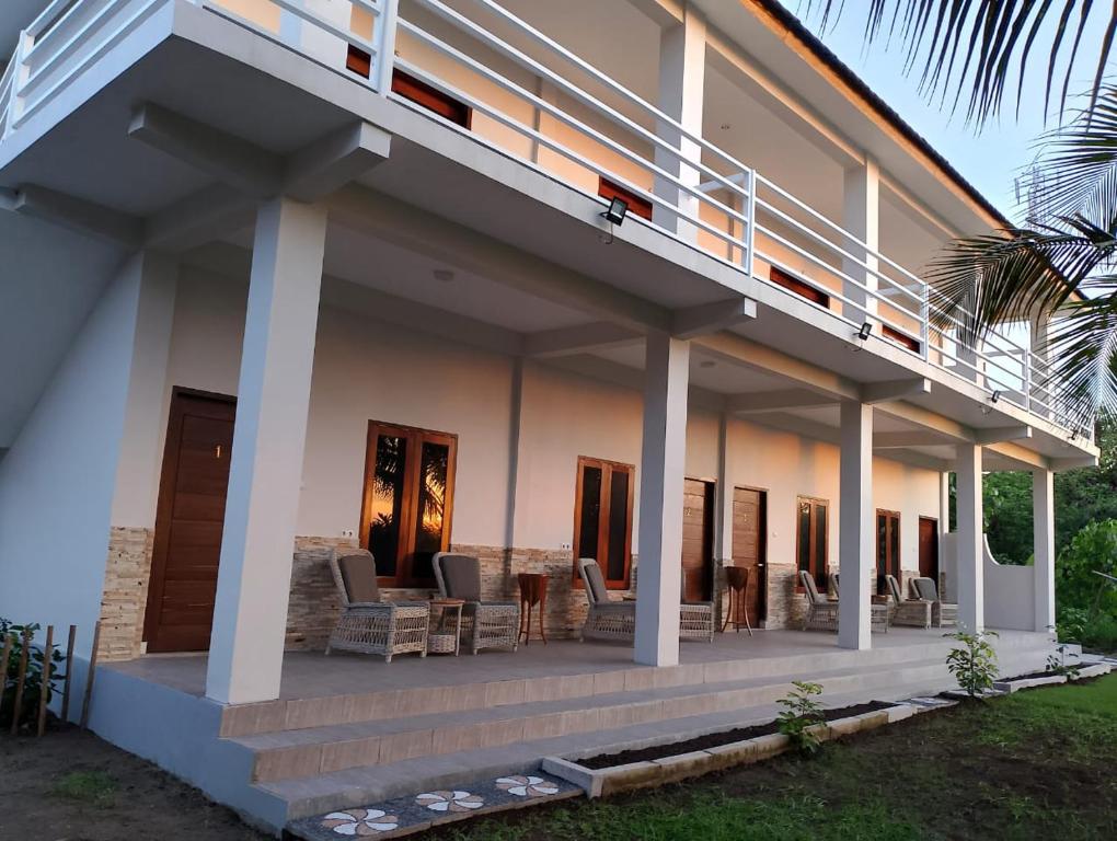 une maison avec une terrasse couverte et un balcon dans l'établissement Mama Nings Beach Hotel, à Sekongkang