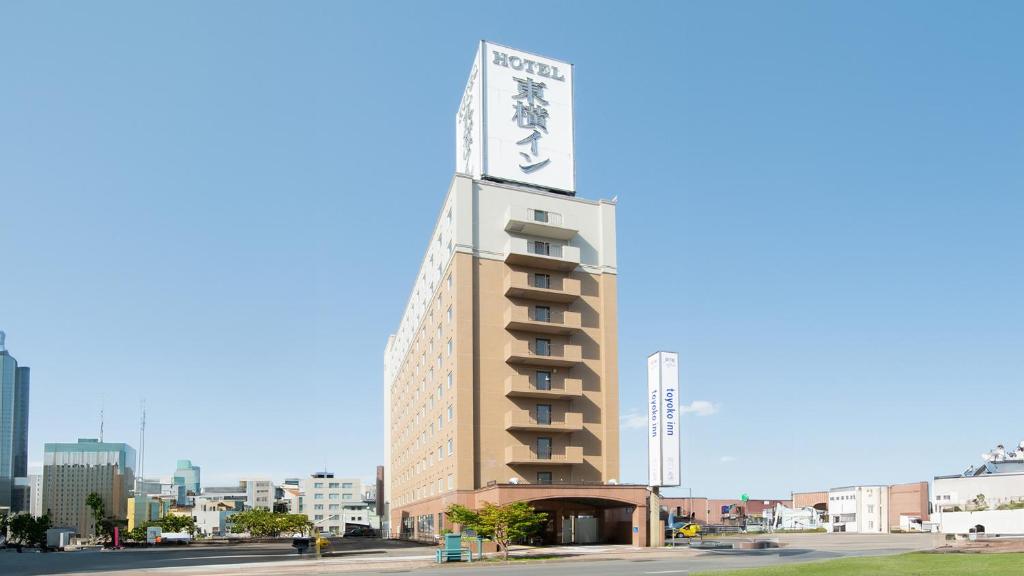 um edifício alto com um sinal em cima em Toyoko Inn Hokkaido Asahikawa Ekimae Ichijo dori em Asahikawa