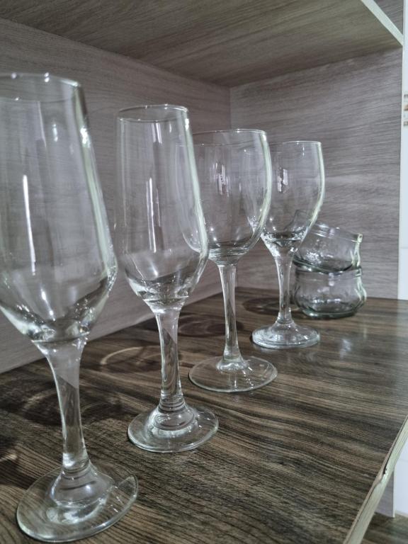 un gruppo di bicchieri da vino seduti su un tavolo di Casa inteira Ipatinga a Ipatinga