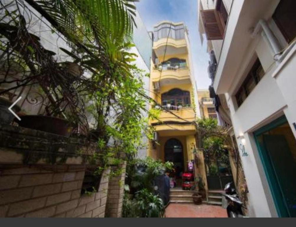 a tall yellow building with a balcony on it at Nemohouse_homestay in Hanoi