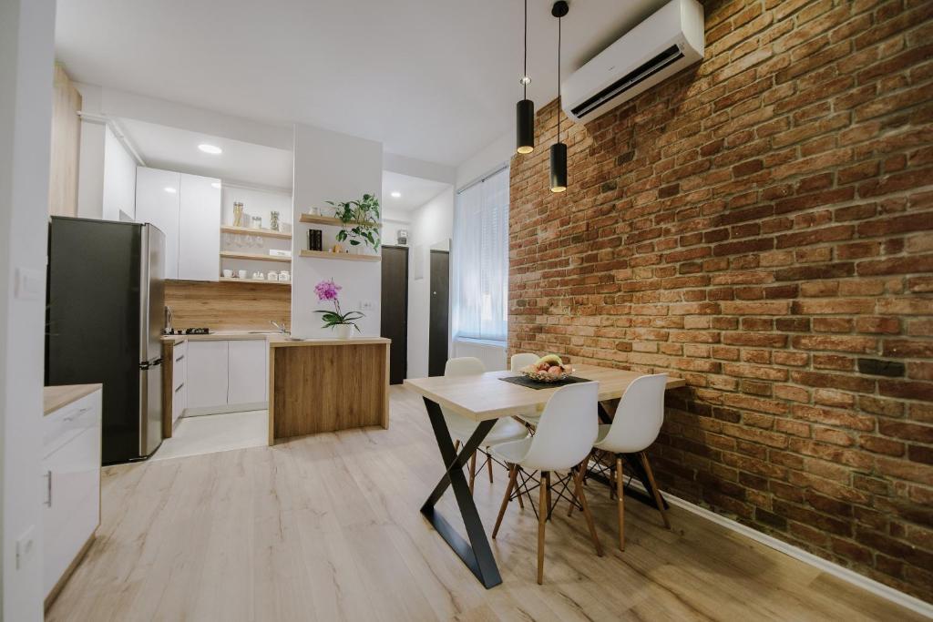 a kitchen and dining room with a brick wall at Apartment British Square with parking in Zagreb