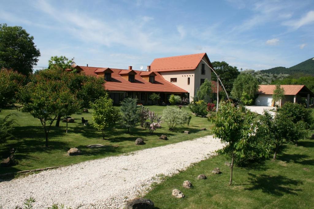 een huis met een grindweg voor een gebouw bij Malomdűlő Farmház in Pilisborosjenő
