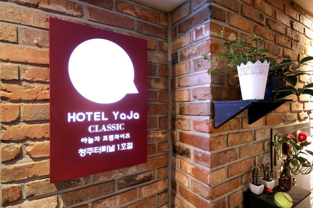uma placa numa parede de tijolos com um hotel yoda clássico em Hotel Yaja Cheongju Terminal Branch em Cheongju