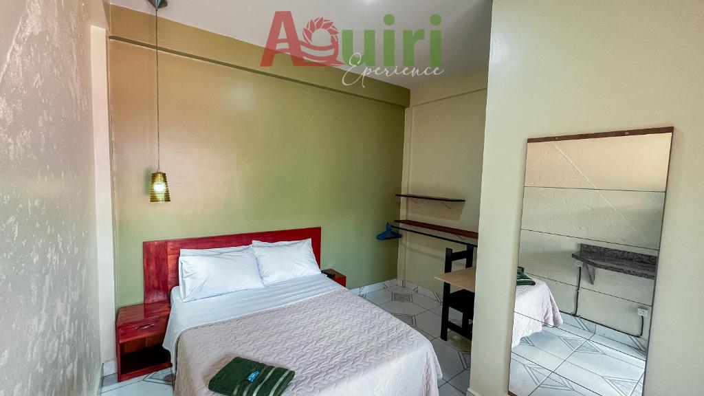 Dormitorio pequeño con cama y espejo en Alojamiento céntrico, en Cobija