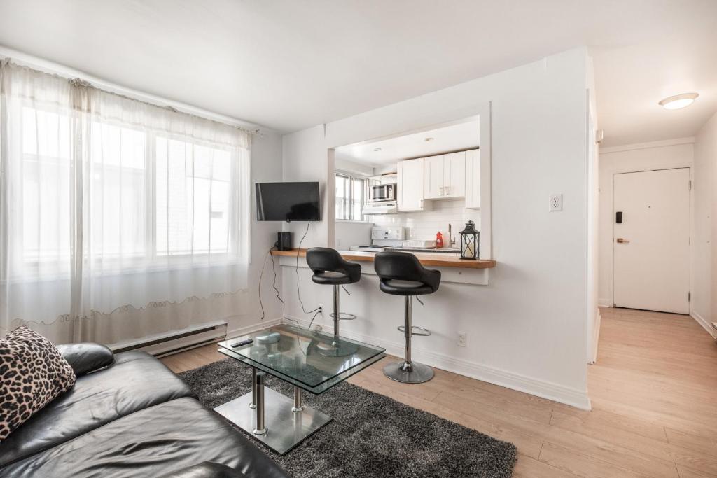 een woonkamer met een bank en 2 stoelen bij Cozy one bedroom apartment in the heart of downtown - 329 in Montreal