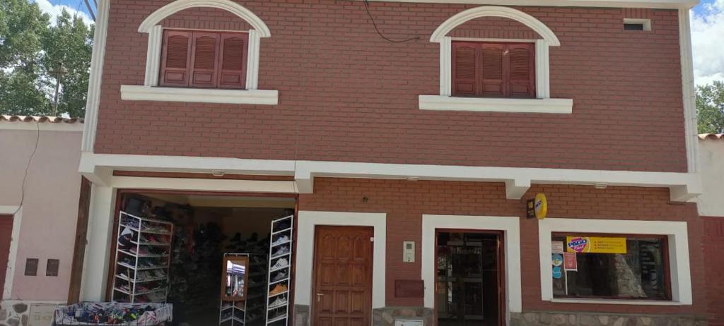 a red brick building with two windows and two doors at HOSTAL DOÑA BERTA in Humahuaca