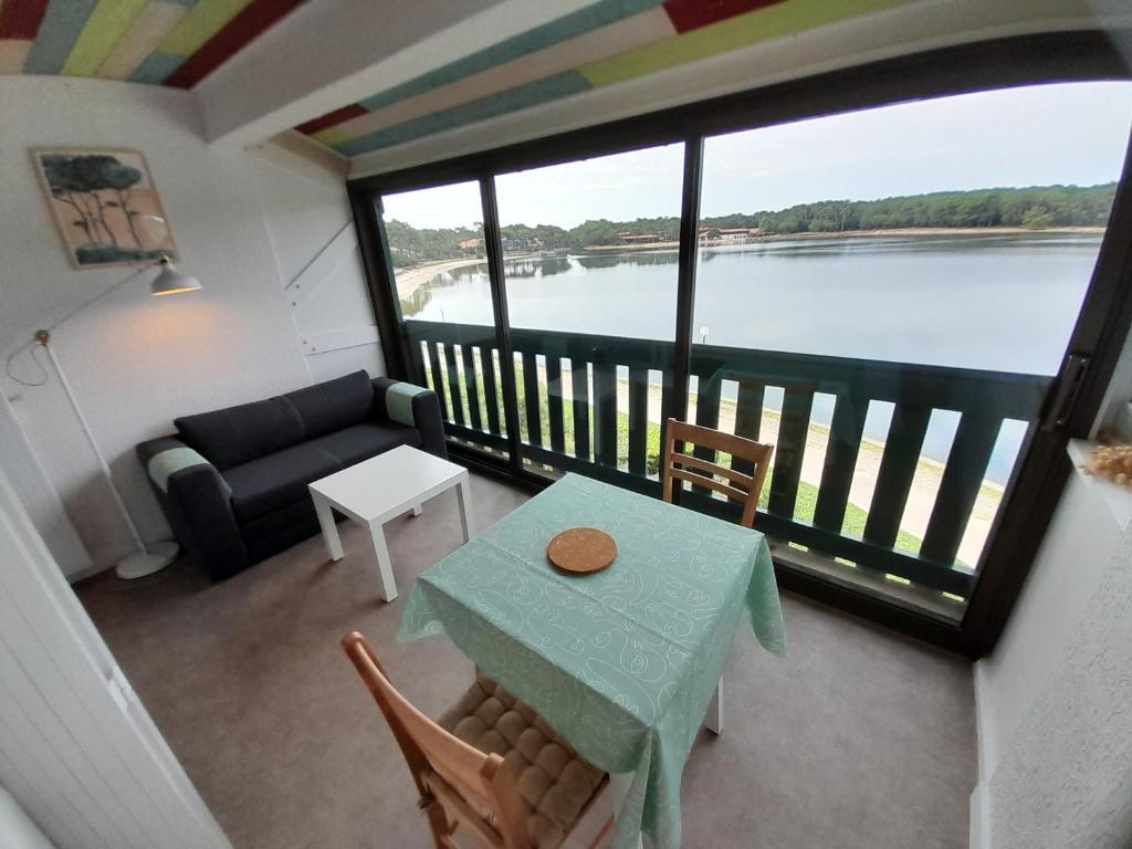 un salon avec une table et une vue sur un lac dans l'établissement Studio moderne rénové au bord du lac pour deux personnes à Vieux Boucau - FR-1-239-991, à Soustons