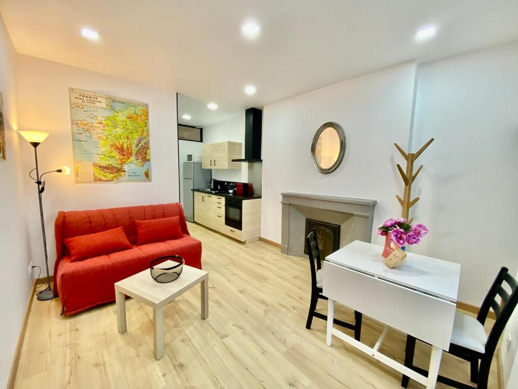 a living room with a red couch and a table at Cathedral: Cosy in the heart of the city center in Poitiers