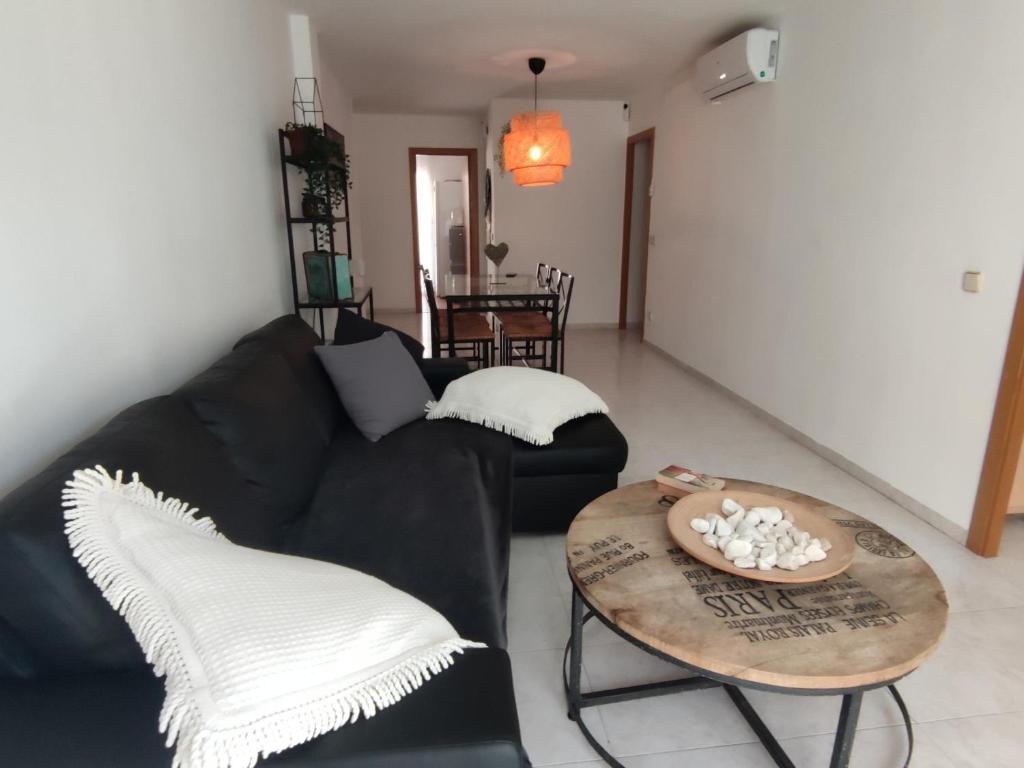 ein Wohnzimmer mit einem schwarzen Sofa und einem Tisch in der Unterkunft Apartamento Platja d'Aro, 3 dormitorios, 6 personas - ES-209-47 in Platja  d'Aro