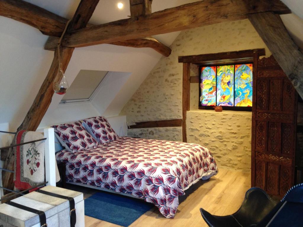 une chambre avec un lit et un vitrail dans l'établissement Ancien Fournil Cosy avec Piscine Couverte, Parc Verdoyant et Sauna, à 30 mn du Mans - FR-1-410-432, à Vivoin