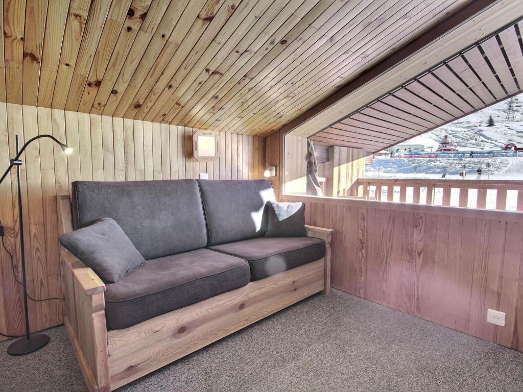 - un canapé dans une pièce dotée d'un mur en bois dans l'établissement Appartement 2 pièces avec balcon et vue sur pistes, animaux admis - FR-1-455-252, à La Plagne Tarentaise