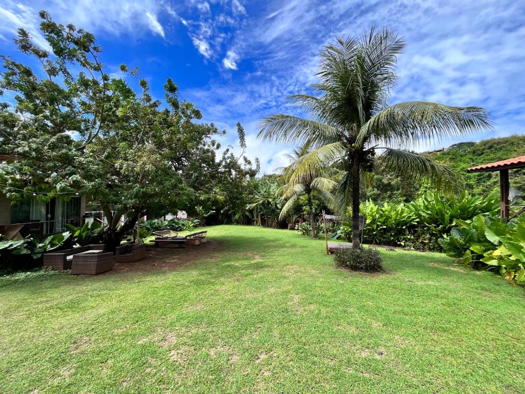 a lawn with a palm tree in a yard at Pousada Simpatia da Ilha in Fernando de Noronha