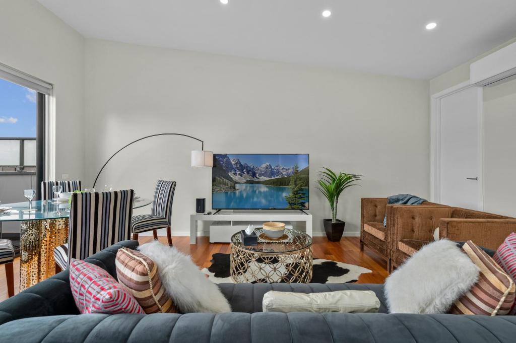 a living room with a couch and a table at Churchill Delux, close to Western health 10 min to Cbd in Braybrook