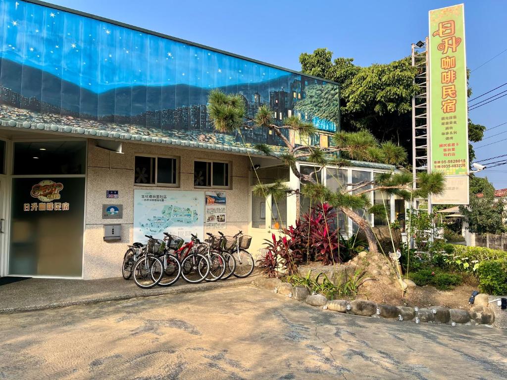 een groep fietsen geparkeerd buiten een gebouw bij 日升咖啡民宿 in Gukeng