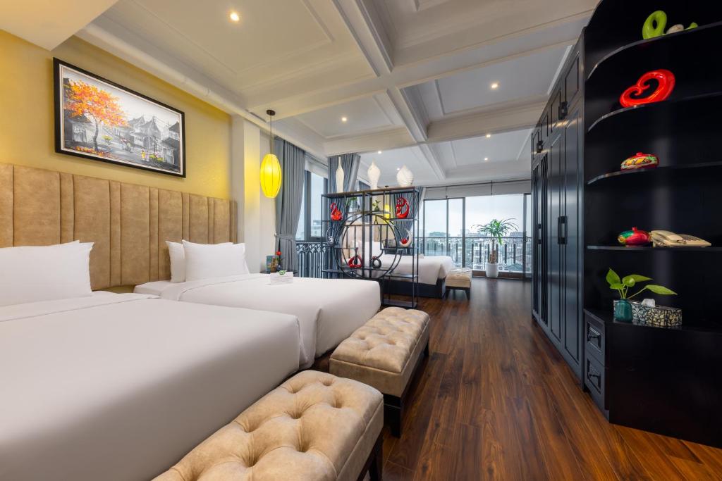 Golden Legend Boutique Hotel في هانوي: غرفة فندقية بسريرين واريكة