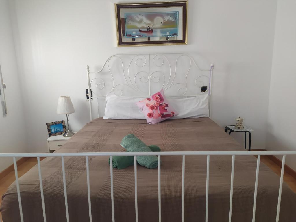 a bed with a white headboard and a stuffed animal on it at Apartamento junto a la Basilica del Pilar in Zaragoza