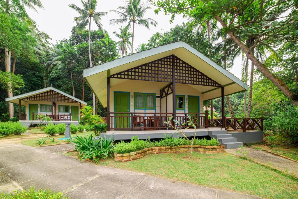 a small house with a porch in a forest at Nirwana Beach Club in Lagoi