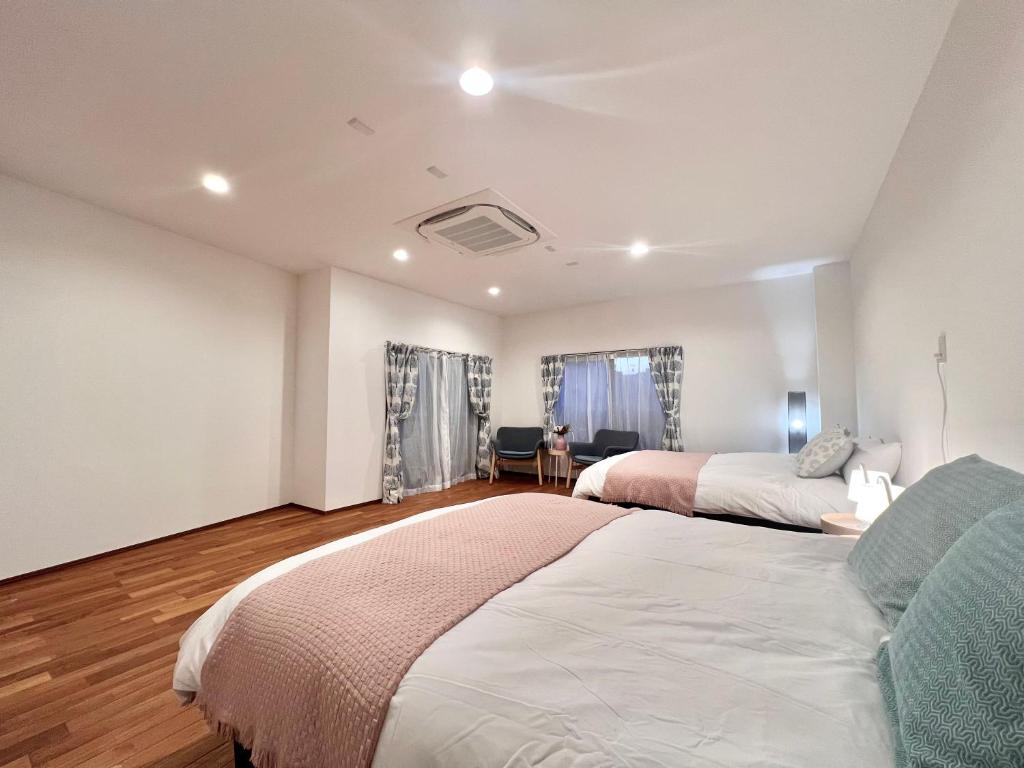 a bedroom with two beds and a couch at S-asakusa in Tokyo