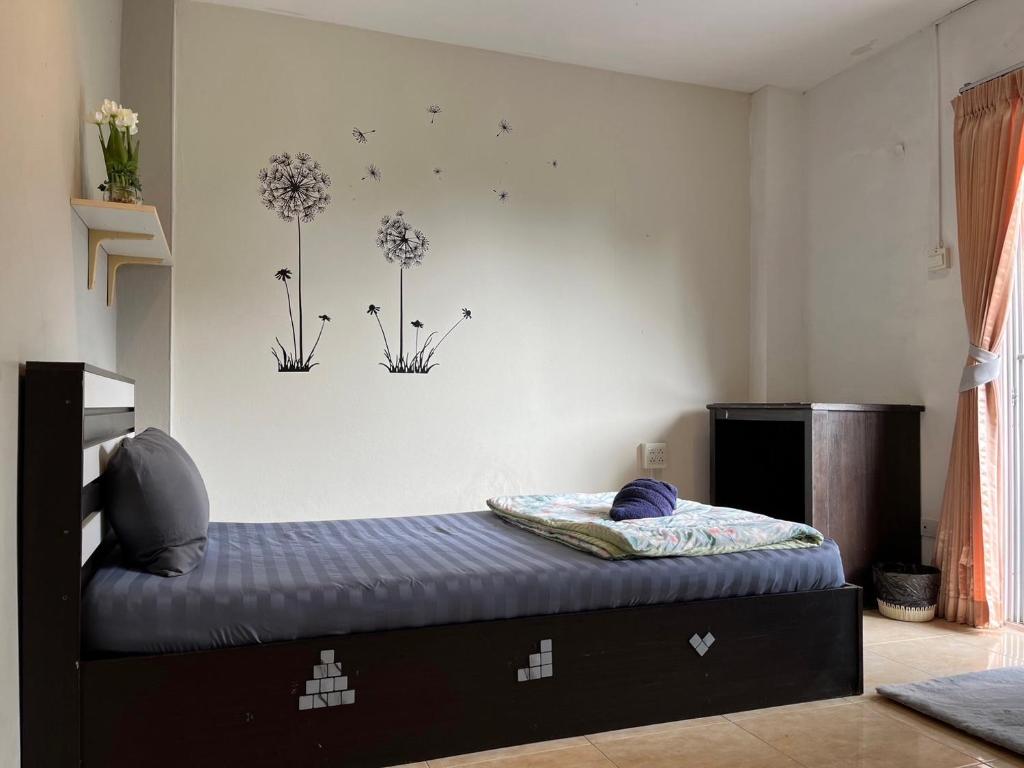 a bedroom with a bed with dandelions on the wall at ALPHA Hostel Cafe&Bar in Ban Khlong Yai