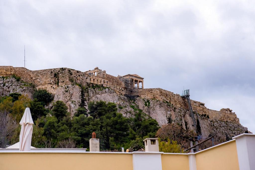 un edificio al lado de una montaña en Athens Muses Suites, en Atenas