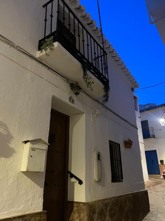 Edificio blanco con puerta y balcón en Casa Miguelito en Comares