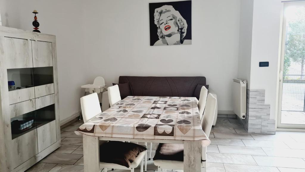 ein Esszimmer mit einem Tisch und einem Hund darunter in der Unterkunft La Casa di Anastasya in Gassino Torinese