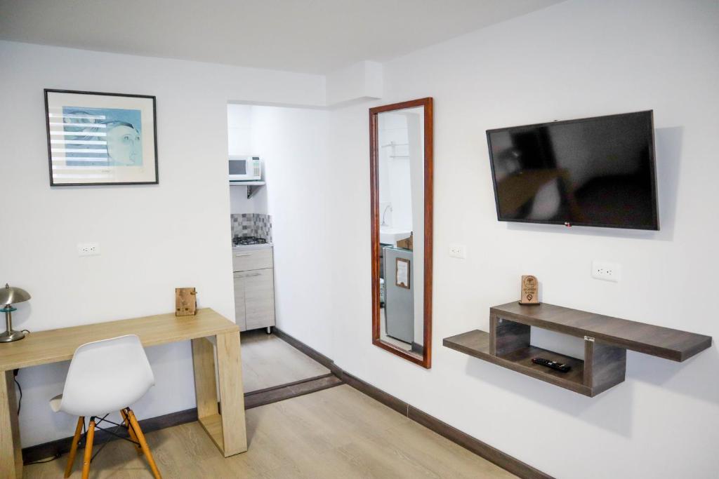 馬尼薩萊斯的住宿－Apartahotel La Arboleda HC，一间设有镜子、一张桌子和一把椅子的房间
