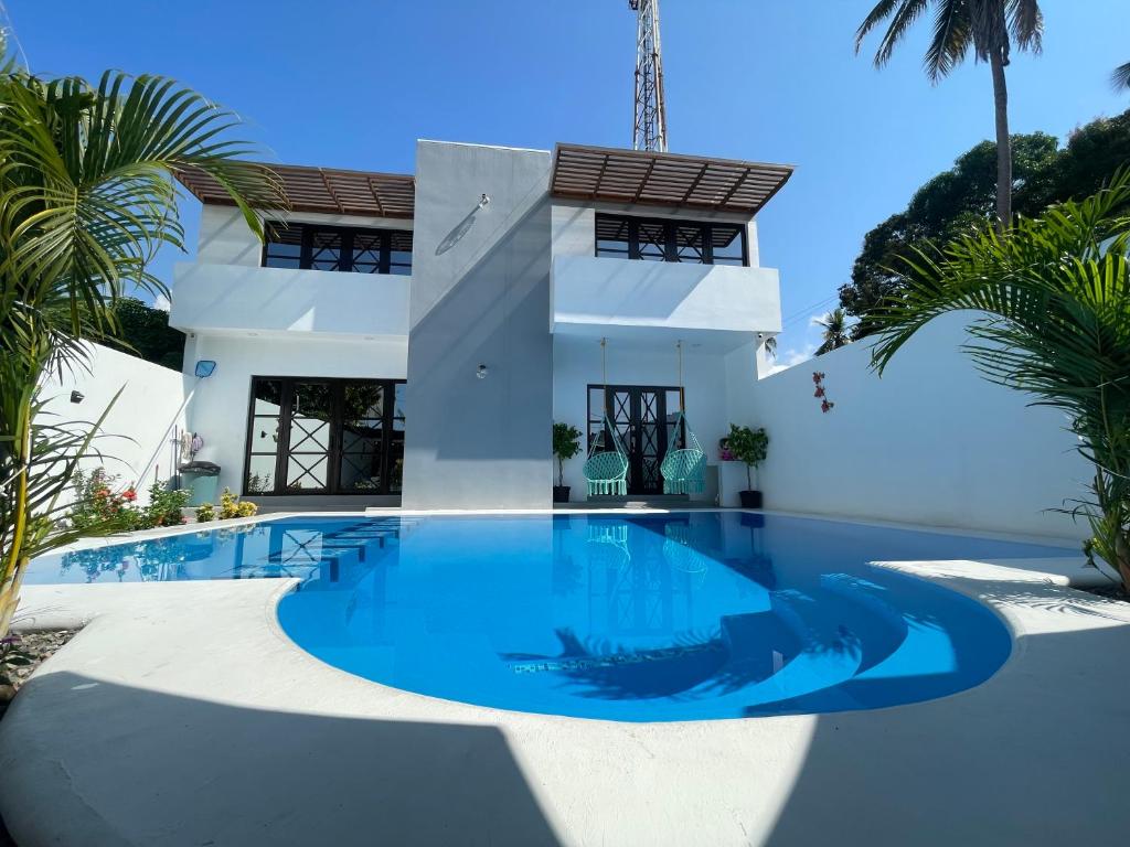 - une piscine en face d'une maison avec des palmiers dans l'établissement Casa AbrahamMya Playa Linda 3 bed home with pool., à El Desengaño
