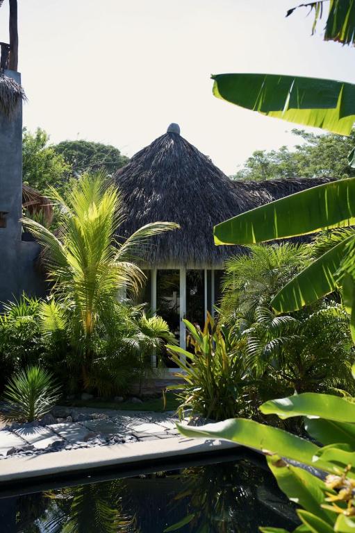 a resort with a pool in front of a building at Casa MexiBali, Palapita in Troncones