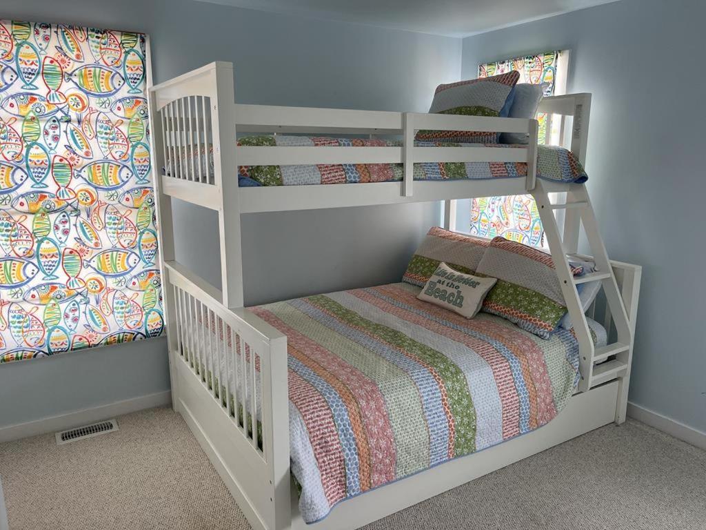 a childs bedroom with a bunk bed and a crib at Hear The Ocean From This Well Kept Oceanside Duplex in Brant Beach
