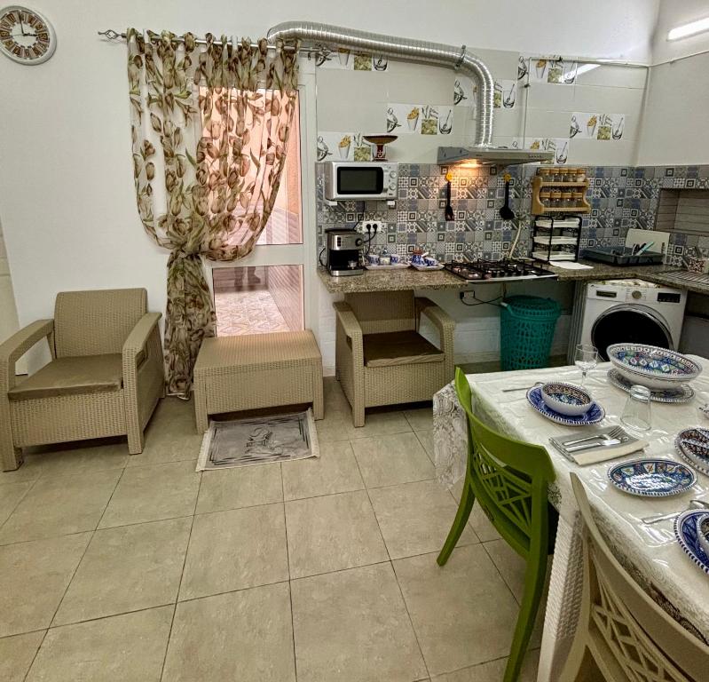 a kitchen with a table and some chairs and a counter at MAHDIA BORJ ERRAS (CAP AFRICA) in Mahdia