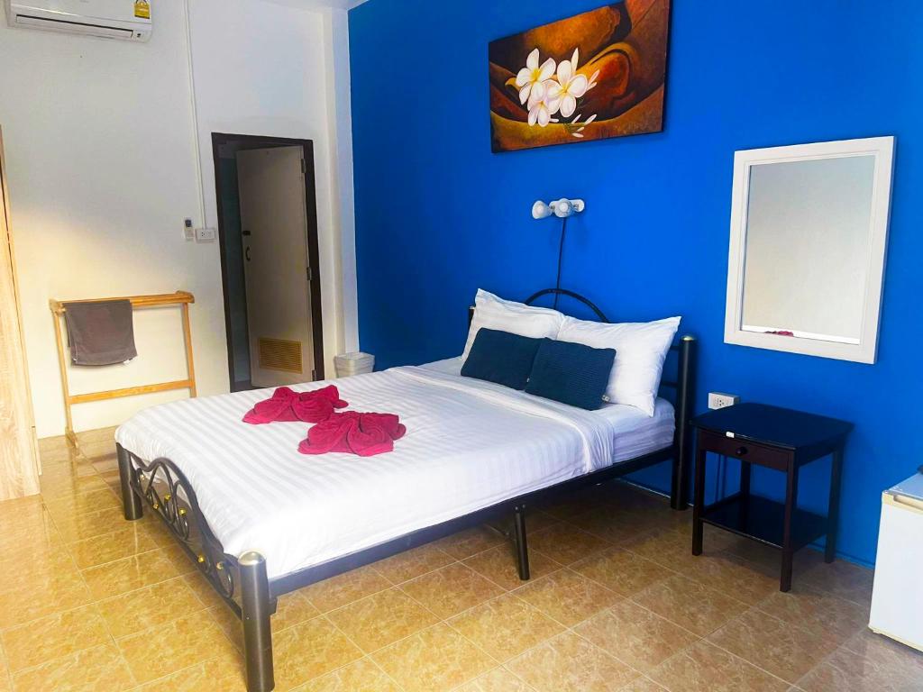 Lodge Annex في بوفوت: غرفة نوم زرقاء مع سرير مع زهور حمراء عليه