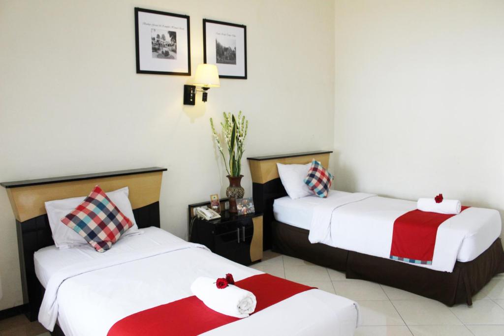 Postel nebo postele na pokoji v ubytování Hotel Pelangi Malang, Kayutangan Heritage