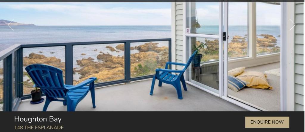 2 blaue Stühle auf einem Balkon mit Meerblick in der Unterkunft Pacific Ocean House seafront 3bd2bh near airport in Wellington