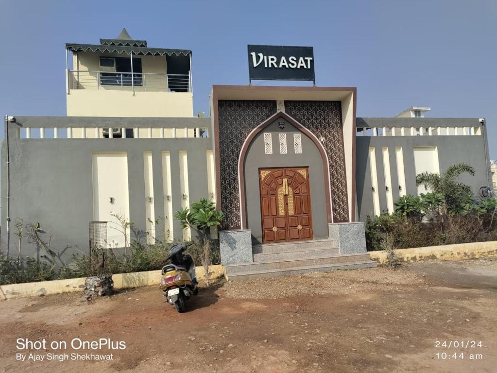 a motorcycle parked in front of a building with a door at Virasat The Tent Villa in Jaipur