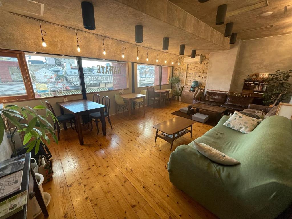uma sala de estar com um sofá e uma mesa em Nawate Guesthouse em Matsumoto