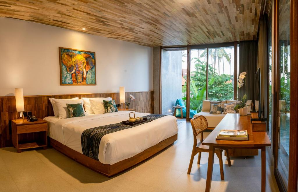 Ketewel的住宿－Langit Pitu Villas，一间卧室配有一张大床和一张桌子