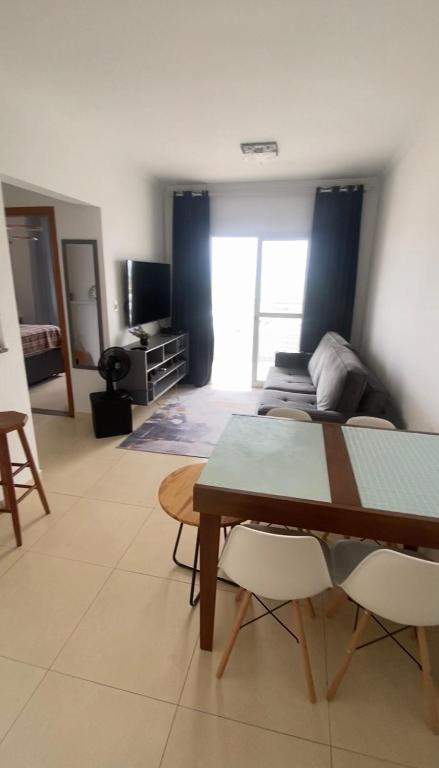 a living room with a bed and a table at Apartamento Vila Tupi in Praia Grande