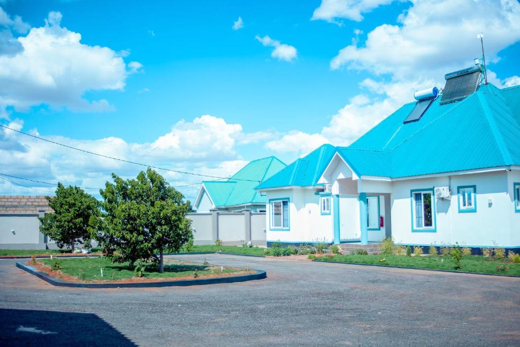 eine Reihe von weißen Häusern mit blauen Dächern in der Unterkunft Teranga Lodge and Restaurant in Ihumwa