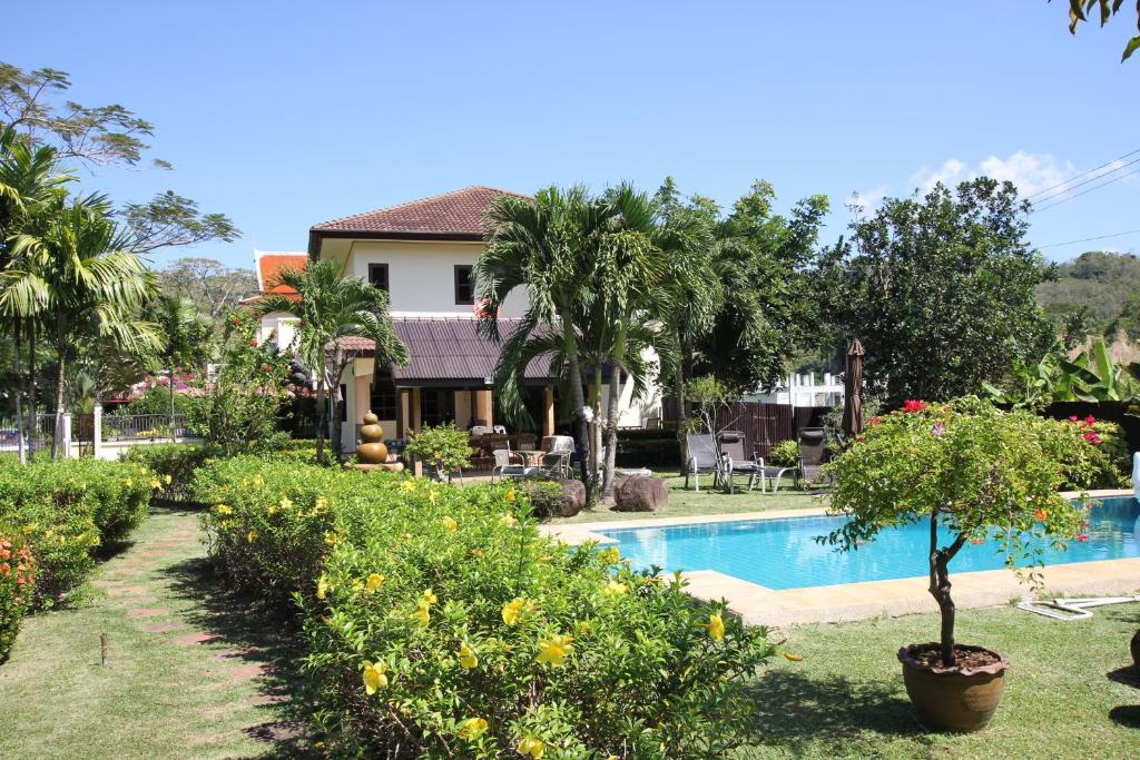 un complexe avec une piscine et une maison dans l'établissement Bann Jai Dee, à Nai Yang Beach