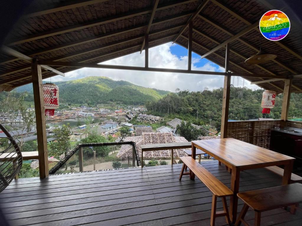 une terrasse en bois avec une table et des chaises. dans l'établissement Hedreung banrakthai homestay and camping, à Ban Rak Thai