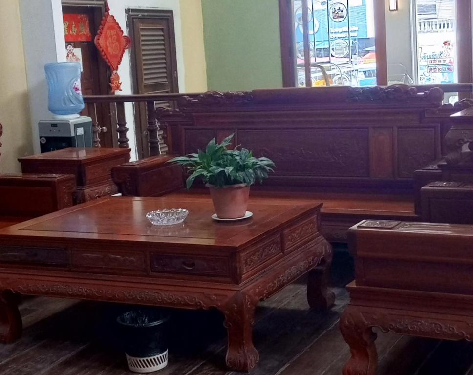 un soggiorno con tavolo in legno e pianta in vaso. di Dansavanh Hotel a Muang Xai