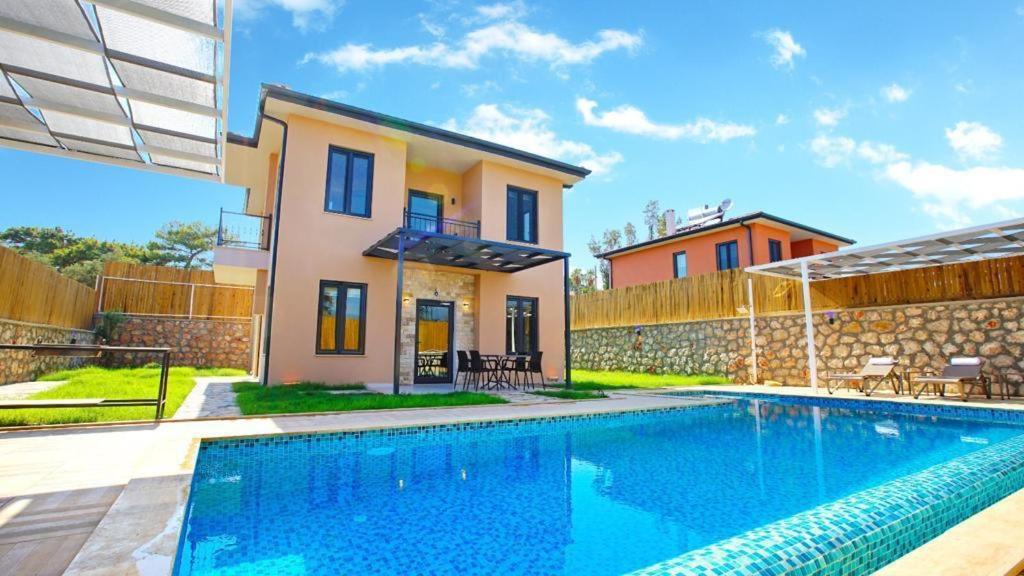 a villa with a swimming pool in front of a house at Villa Ersan 3 in Kas